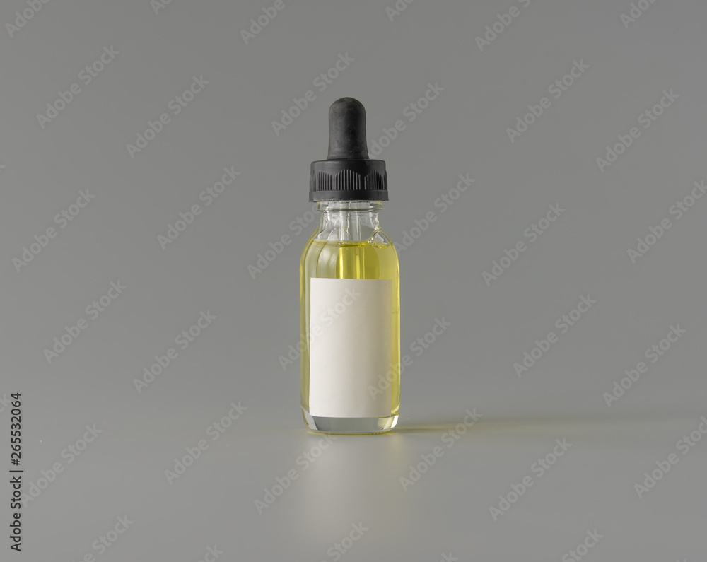 Bottle of essential oil with blank label on grey background for print design and mock up Bottle of essential oil with blank label on grey background for print design and mock up