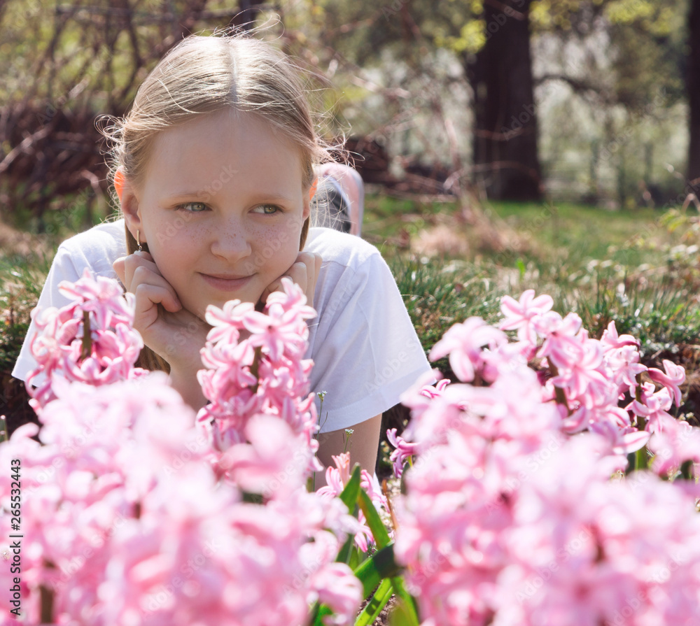 Beautiful slim little girl teenager walks in the flowered garden. Children's portrait. Spring. The game is in the open air. Summer educational camp. Beautiful slim little girl teenager walks in the flowered garden. Children's portrait. Spring. The game is in the open air. Summer educational camp.