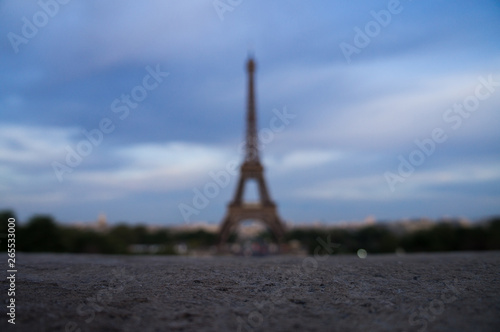 Eifel Tower in blur with foreground stone surface in focus taken from Trocadero in France Paris 