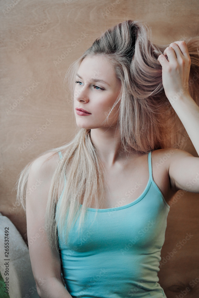Young beautiful athletic woman blonde in sportswear sitting by the window of a cafe against the background of a wooden wall. Young beautiful athletic woman blonde in sportswear sitting by the window of a cafe against the background of a wooden wall.