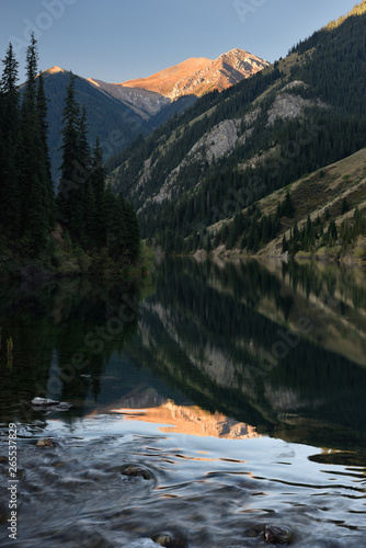 Sunny peak reflected in Lower Kolsai Lake in Kungey Alatau mountains Kazakhstan photo