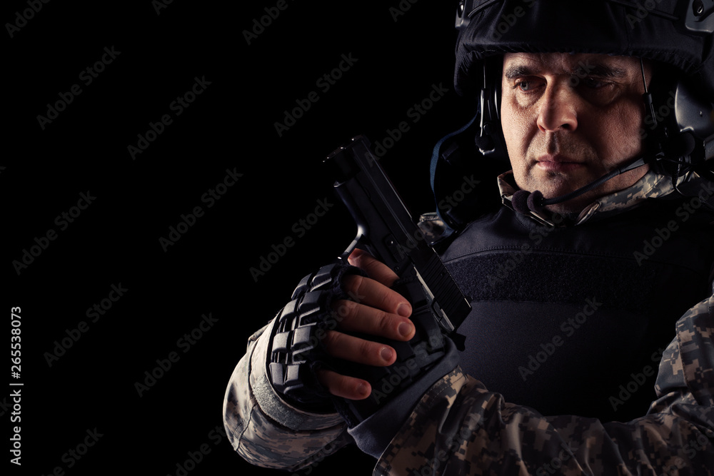 Soldier aiming with black pistol. Image on a dark background. Soldier aiming with black pistol. Image on a dark background.