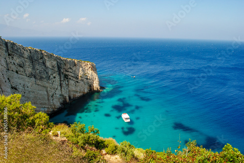 Zakynthos Island coast line, with crystal clear waters and a isolated boat in summer.
