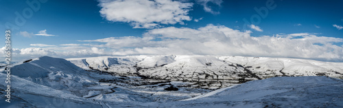 A panoramic view of the peak district in winter with snow on the mountains from a high postion.