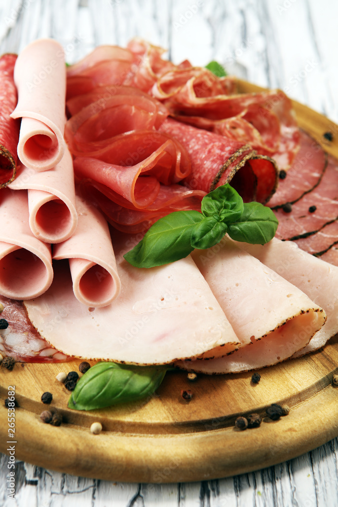 Food tray with delicious salami, pieces of sliced ham, sausages,salad and vegetable. Meat platter with selection Food tray with delicious salami, pieces of sliced ham, sausages,salad and vegetable. Meat platter with selection