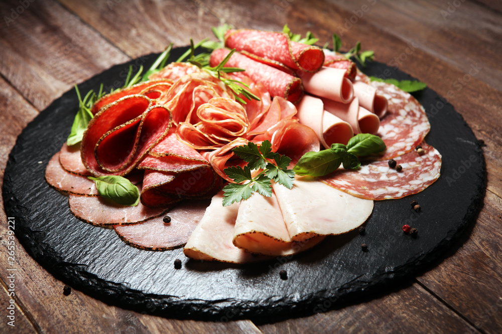Food tray with delicious salami, pieces of sliced ham, sausages,salad and vegetable. Meat platter with selection Food tray with delicious salami, pieces of sliced ham, sausages,salad and vegetable. Meat platter with selection