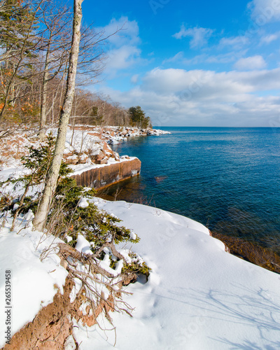 Beautiful trees and Lake Superior coastline in the cold and snow at Big Bay State Park - Madeline Island in Northern Wisconsin - sunny day with blue skies