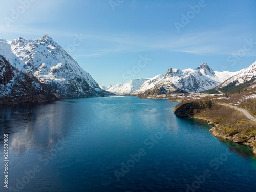 Road along fjord and mountain with snow cap in Norway