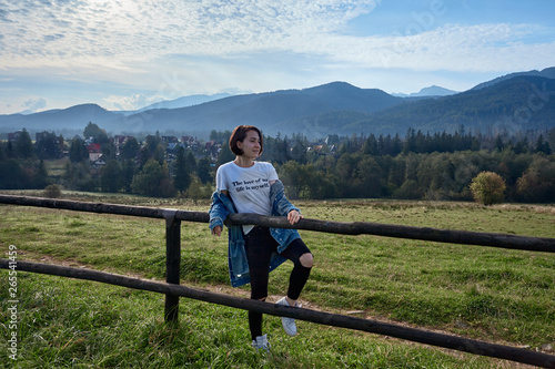 Girl sitting on grass. Mountains as a background © Sotnikow