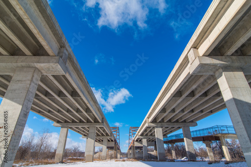 Underside state highway bridges that go over the Minnesota River south of the Twin Cities - great straight lines, symmetry, and blue skies © natmacstock