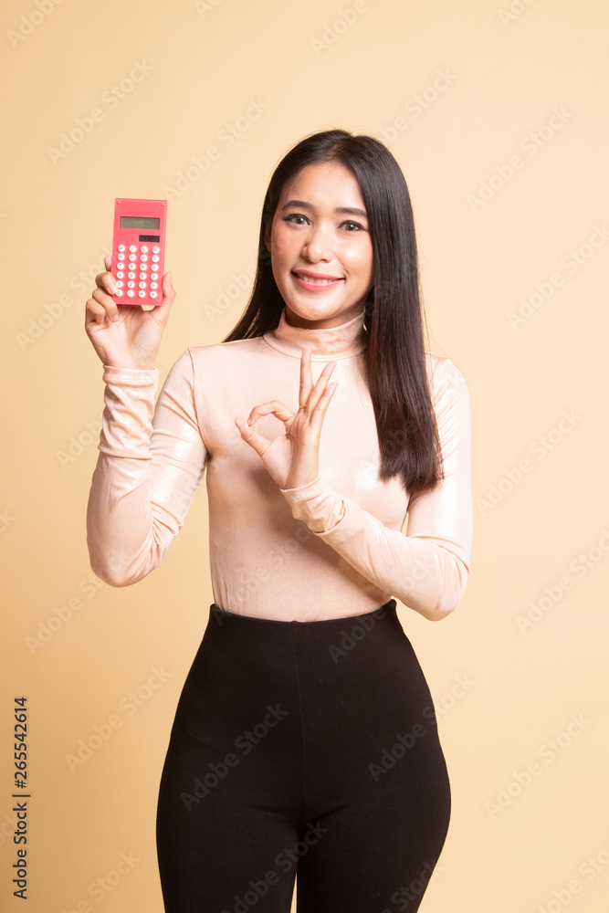 Asian woman show OK with calculator. Asian woman show OK with calculator.
