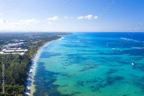 Aerial view from drone on tropical beach with palm trees and speed boats in caribbean sea