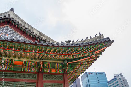 Traditional temple with modern skyscraper in background - Historic culture and economic future - Deoksugung, South Korea