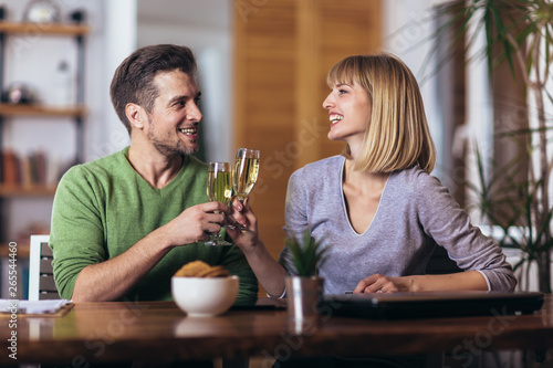 Couple talking in the night in the living room at home and drink wine.