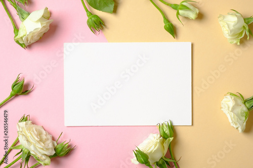 Blank paper card and frame border of roses flower on pastel background. Flat lay composition, top view, overhead. Banner mockup for women or mothers day, birthday. Concept of tenderness, love, nature