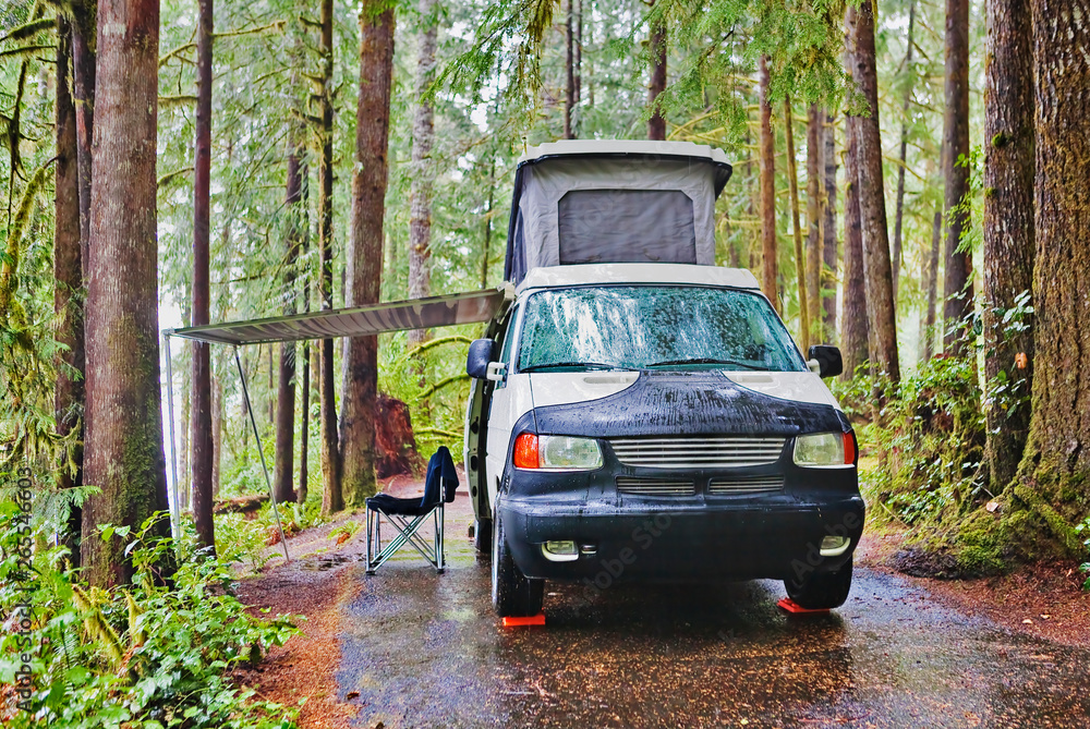 Camper van with awning parked at campsite Camper van with awning parked at campsite