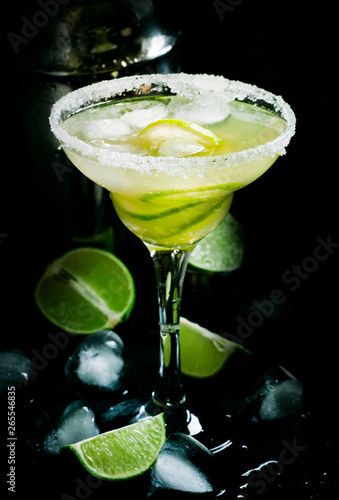 Lime Daiquiri cocktail in glass, black bar counter background, selective focus
