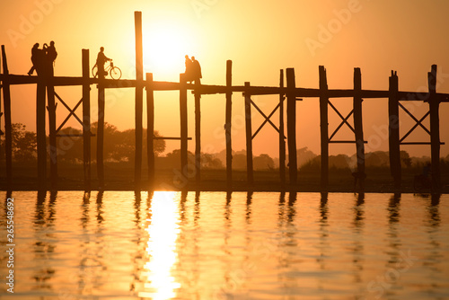 People walking on elevated wooden walkway at sunset photo