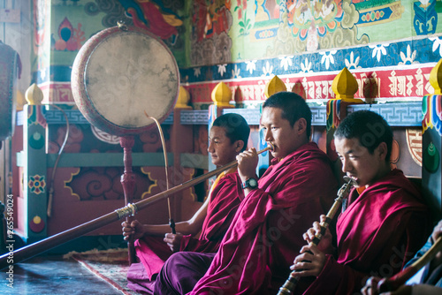 Asian monks playing instruments on temple floor photo