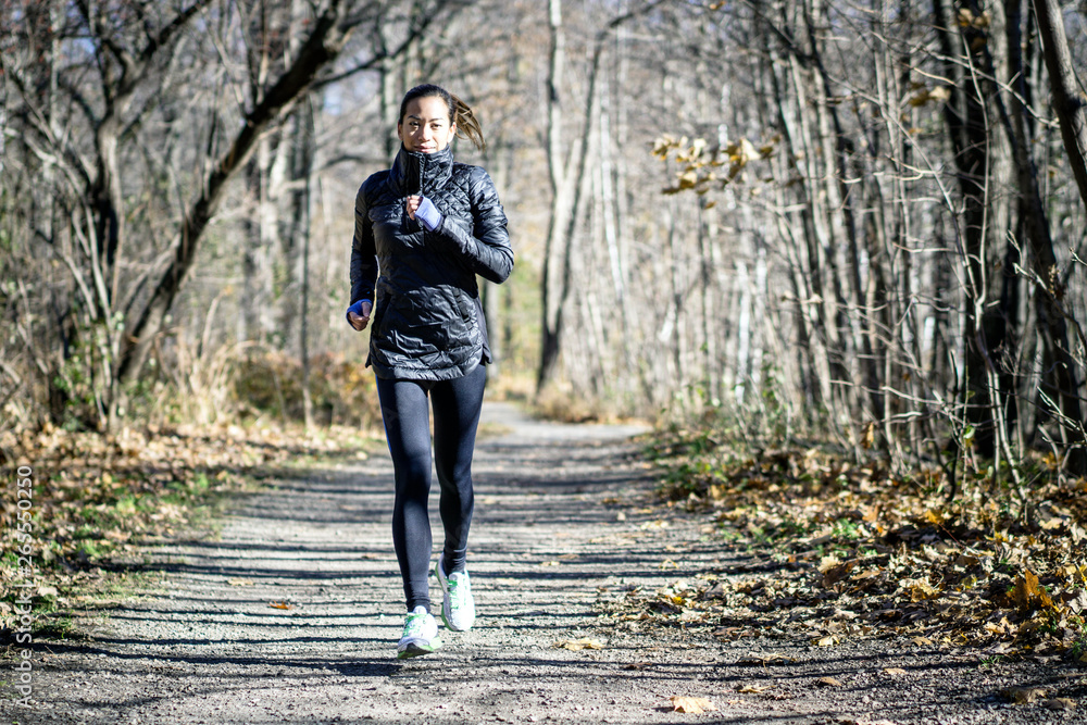 Woman running on dirt path in autumn Woman running on dirt path in autumn