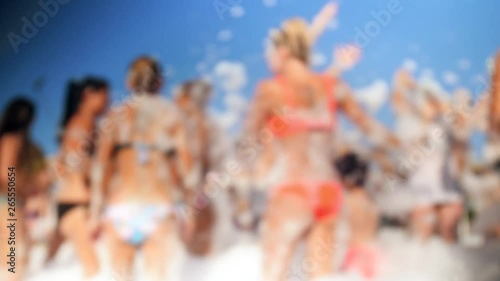 4k blurred video of cheerful crowd dancing on the soap beach party. Soap bubbles flying around. photo