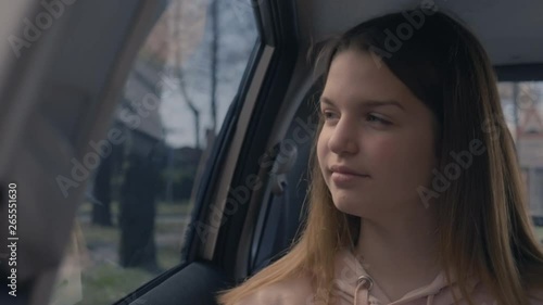 CU of a teen girl driving in the car and looking through the window photo