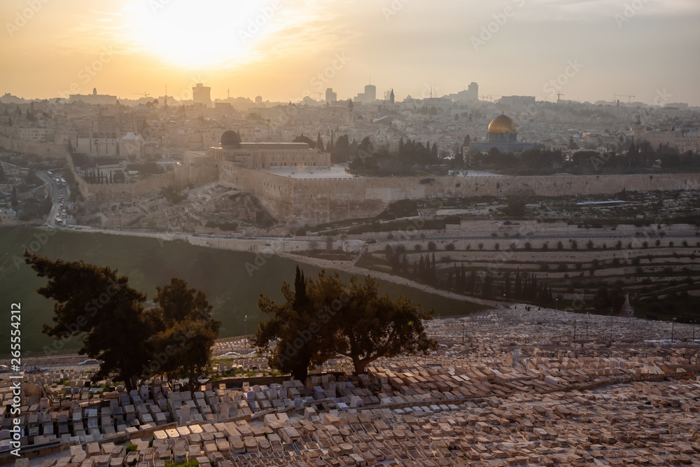 Beautiful aerial view of the Old City, Tomb of the Prophets and Dome of the Rock during a sunny and cloudy sunset. Taken in Jerusalem, Capital of Israel.