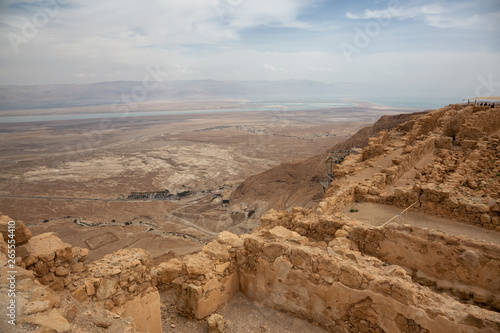 Beautiful view of an ancient fortress on top of a mountain during a cloudy and sunny day. Taken in Masada National Park, Israel.