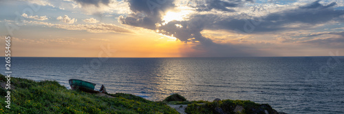 Broken wooden boat on the Ocean Coast duing a vibrant sunset at the Apollonia Beach. Taken in Herzliya, Tel Aviv District, Israel. photo