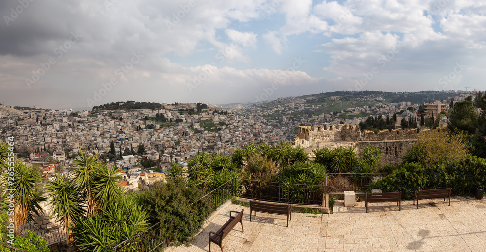 Beautiful panoramic view of the Walls of Jerusalem surrounding the Old City with the cityscape in the background during a cloudy day. Taken near the Jerusalem, Israel.