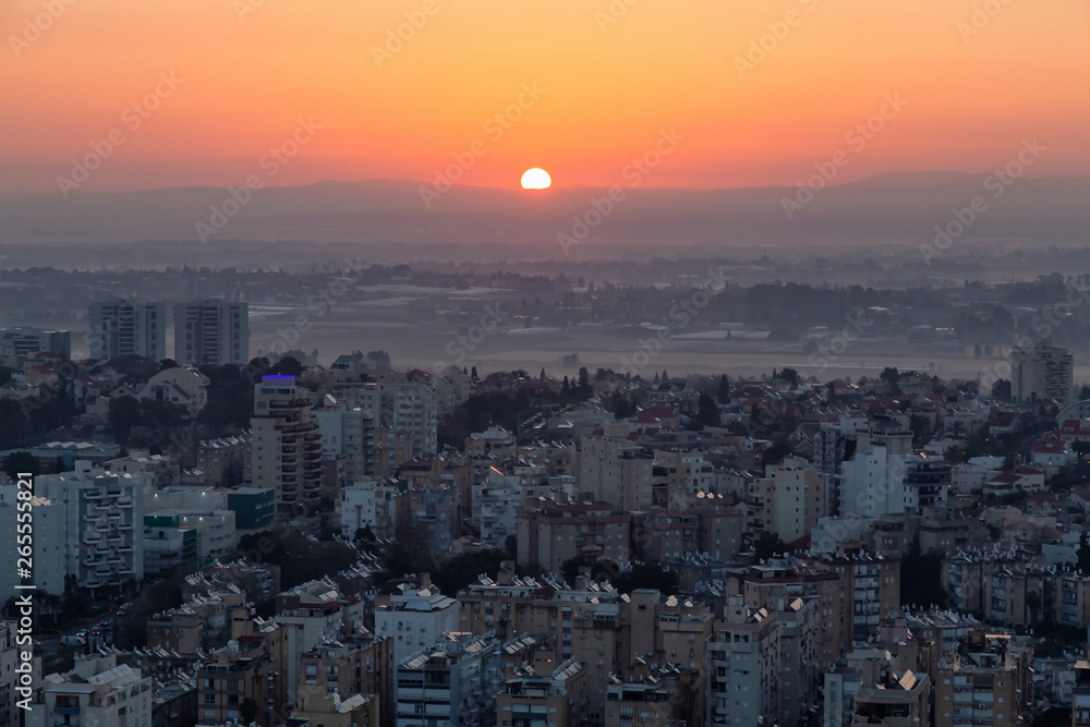 Obraz premium Aerial view of a residential neighborhood in a city during a vibrant and colorful sunrise. Taken in Netanya, Center District, Israel.