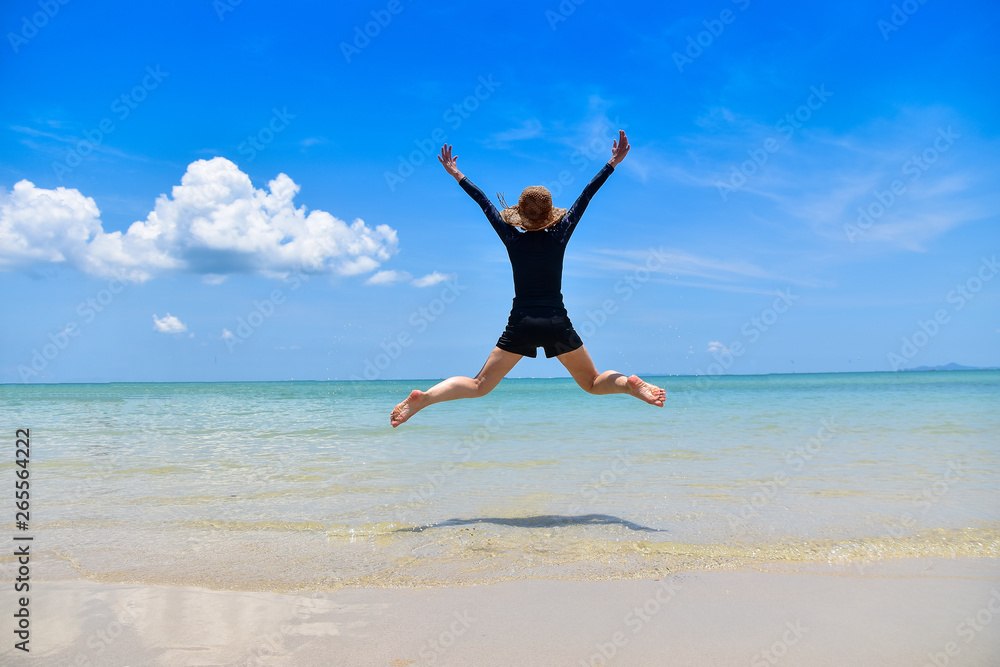 Women jumping on sea beach blue sky background Travel in Summer Holidays