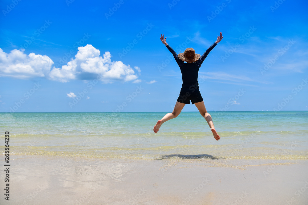 Women jumping on sea beach blue sky background Travel in Summer Holidays Women jumping on sea beach blue sky background Travel in Summer Holidays