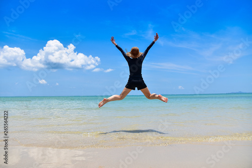 Women jumping on sea beach blue sky background Travel in Summer Holidays