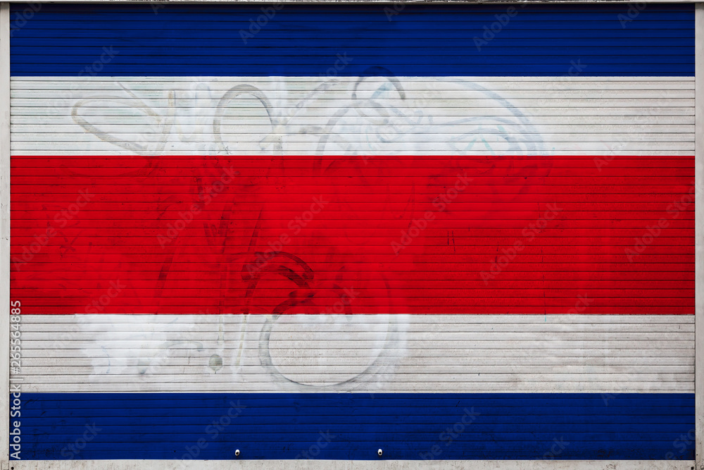 Close-up of old metal wall with national flag of Costa Rica. Concept of Costa Rica export-import, storage of goods and national delivery of goods. Flag in grunge style