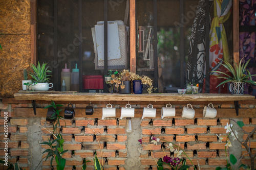 The blurred background of the shop decoration (small glass of water, vase, flowers) that is decorated on the wall or placed on a wooden table for customer service to relax during the service © bangprik