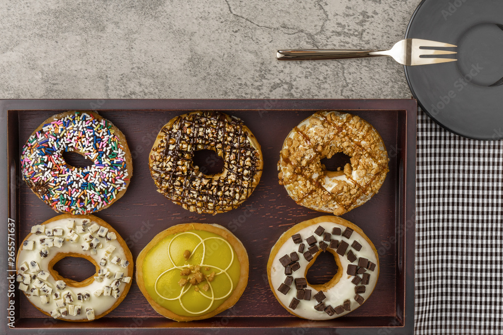 food background of assortment of donuts on wooden tray with napkin fork and small plate food background of assortment of donuts on wooden tray with napkin fork and small plate