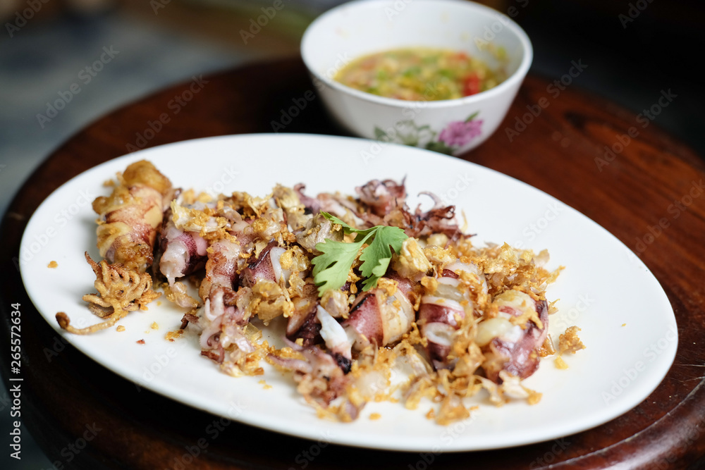 Squid Fried garlic and Seafood sauce in white dish Squid Fried garlic and Seafood sauce in white dish