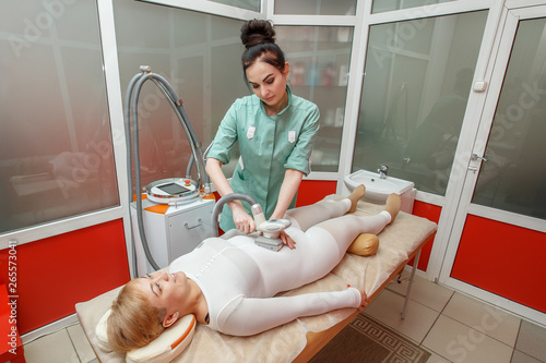 Woman having anti-cellulite lpg massage treatment with apparatus photo