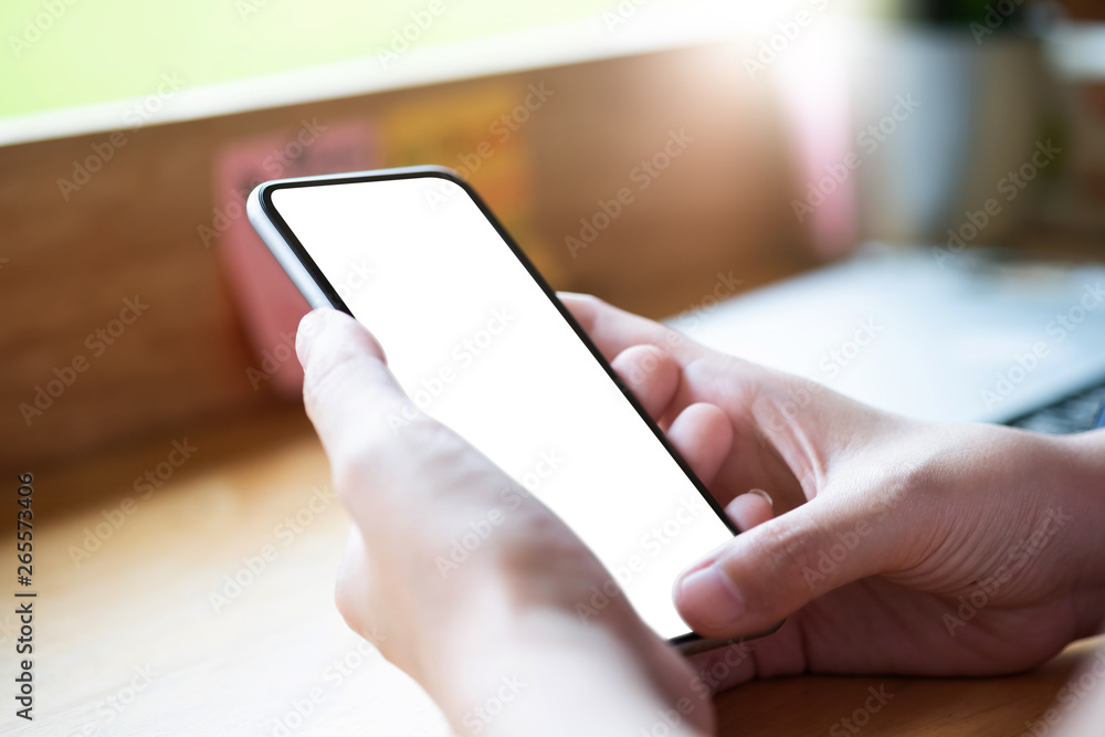 Mockup image of woman's hands holding mobile phone with blank screen in modern cafe Mockup image of woman's hands holding mobile phone with blank screen in modern cafe