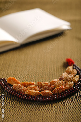 Date fruits with an Islamic prayer beads on an artistic background. Beautiful background for Ramzan or Ramadan. 