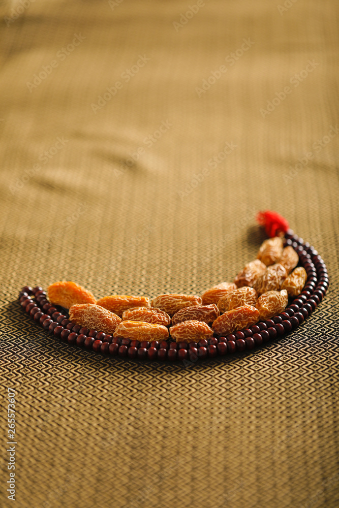Date fruits with an Islamic prayer beads on an artistic background. Beautiful background for Ramzan or Ramadan. Date fruits with an Islamic prayer beads on an artistic background. Beautiful background for Ramzan or Ramadan.
