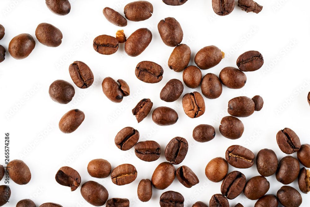 Naklejka premium Scattered coffee beans on a white background.