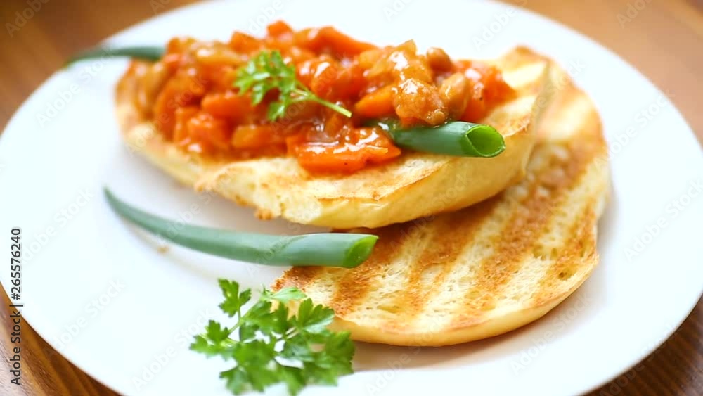fried bread toasts with stewed beans and vegetables in a plate on a wooden table fried bread toasts with stewed beans and vegetables in a plate on a wooden table