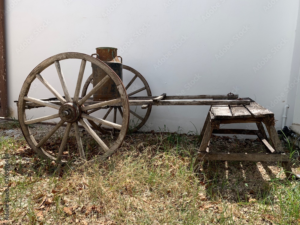 Carretilla antigua en madera para transportar mercancías y recipiente