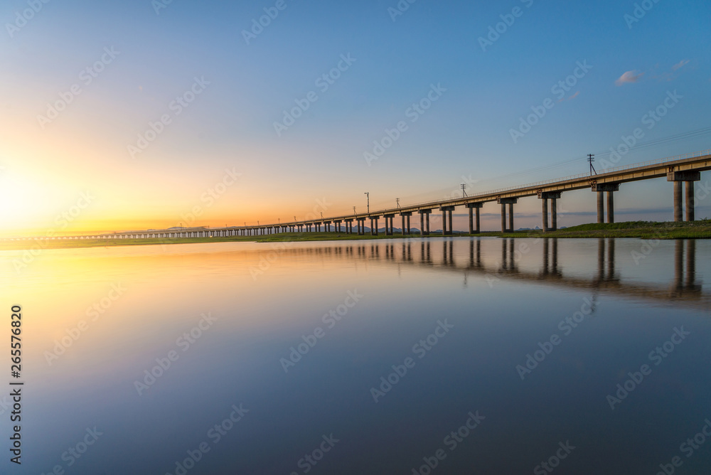 Beautiful sunset scene of railway bridge in lake of pasak Dam , Lopburi , Thailand