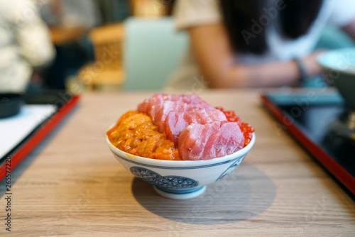 Otoro, ikura and uni donburi - Japanese rice bowl topped with fresh tuna, sea urchin roe, salmon roe, Japanese traditional food. photo