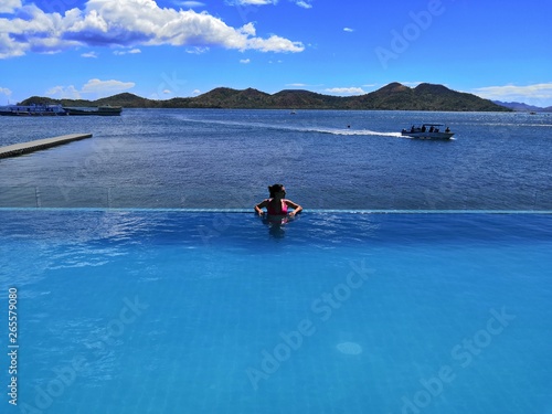Young woman relaxing in infinity pool