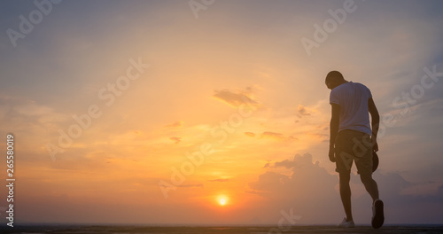 Fototapeta Naklejka Na Ścianę i Meble -  Traveler young man standing in the summer mountains at sunset and enjoying view of nature.