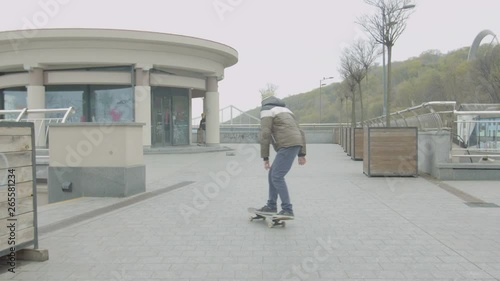 Teen skaters learning doing shuvit tricks, pumping on skateboard sliding down the edge of stairs. Two friends rolling on skates, pushing with feet, practicing skateboard tricks, skating on sidewalk. photo